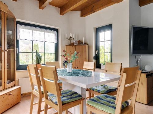 Cosy holiday home in Olsberg with garden في أولسبرغ: غرفة طعام مع طاولة بيضاء وكراسي