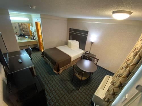 a hotel room with a bed and a bathroom at Deluxe Inn - Fayetteville I-95 in Fayetteville