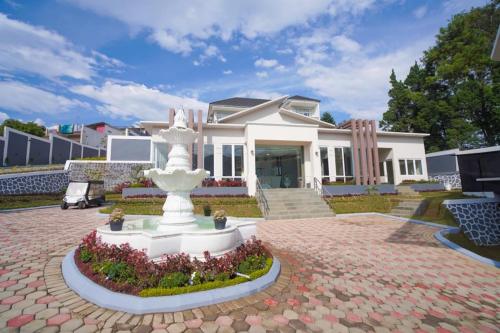 a white fountain in front of a white house at Marseillia Hills in Puncak