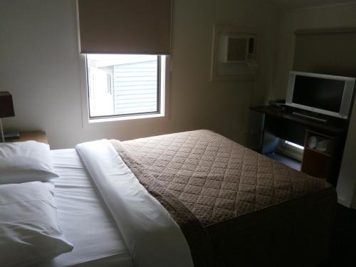a bedroom with a bed with a window and a television at Sovereign Views Apartments in Ballarat
