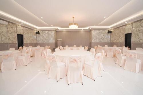 a banquet hall with white tables and white chairs at Marseillia Hills in Puncak