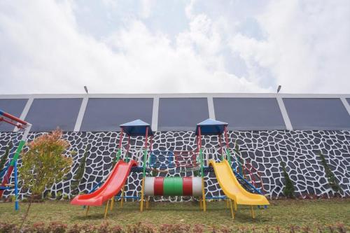 a playground with colorful chairs in front of a fence at Marseillia Hills in Puncak