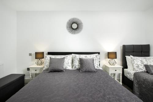 a bedroom with a large bed with a mirror on the wall at Reading Kings Road Lodge by Creatick Apartments in Reading