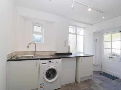 a kitchen with a sink and a washing machine at The Gardens in Bridgwater