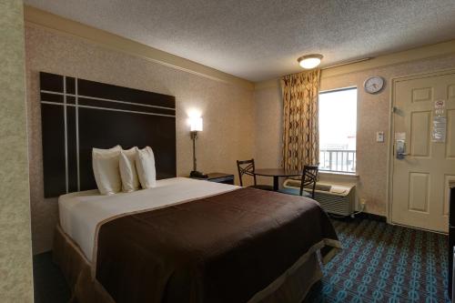 a hotel room with a large bed and a window at Deluxe Inn - Fayetteville I-95 in Fayetteville