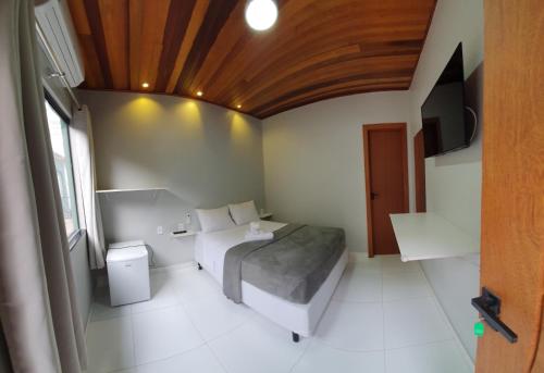 a bedroom with a bed and a television in it at Pousada Mirai -Centro- in Arraial do Cabo