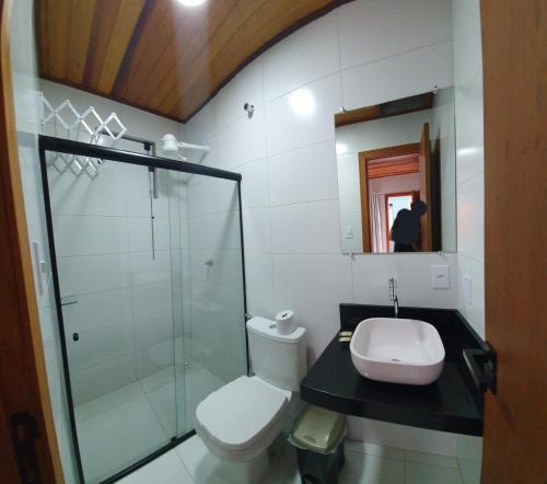 a bathroom with a toilet and a sink and a shower at Pousada Mirai -Centro- in Arraial do Cabo