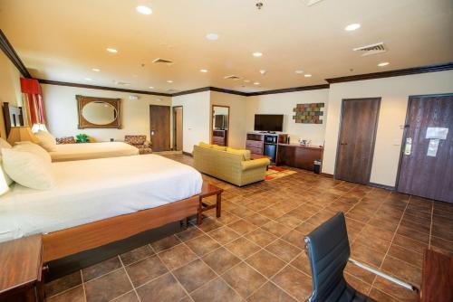 A bed or beds in a room at Best Western PLUS Cimarron Hotel & Suites