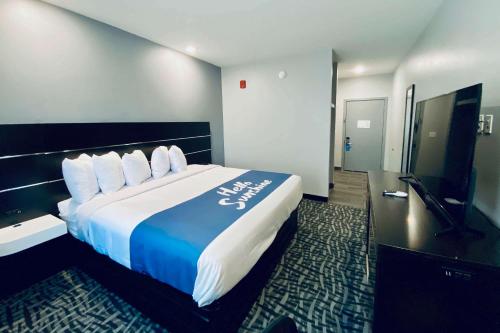 a hotel room with a large bed in a room at Days Inn & Suites by Wyndham Horn Lake - Memphis Graceland in Horn Lake