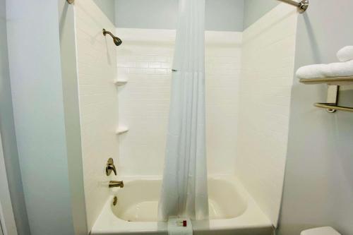 a bathroom with a shower and a tub and a toilet at Days Inn & Suites by Wyndham Horn Lake - Memphis Graceland in Horn Lake