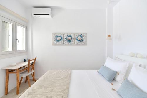 a white bedroom with a bed and a table at Luxury Paros Villa Villa Aethra Beautiful Serene Glisidia in Kampos Paros