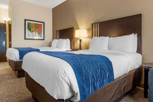 a hotel room with two large beds with blue sheets at Comfort Inn & Suites Butler in Butler