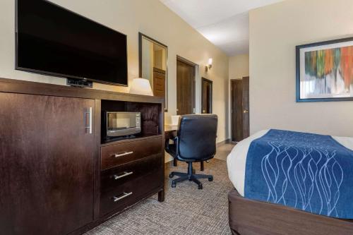 a hotel room with a bed and a flat screen tv at Comfort Inn & Suites Butler in Butler