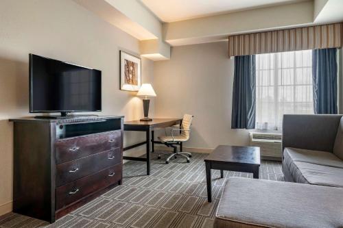 a living room with a flat screen tv and a couch at Comfort Inn & Suites Port Charlotte-Punta Gorda in Port Charlotte