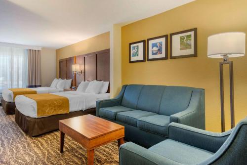a hotel room with a couch and a bed and a room with two beds at Comfort Suites The Villages in The Villages