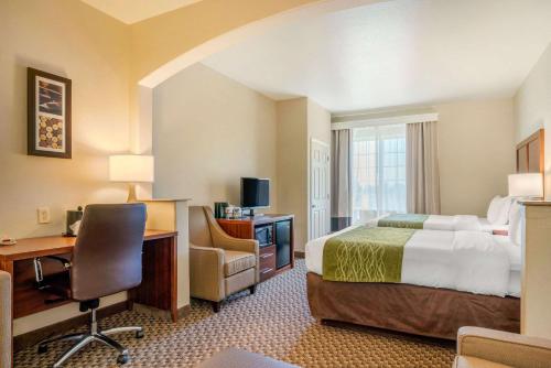 Comfort Inn & Suites Galt – Lodi North في Galt: غرفة فندقية فيها سرير ومكتب وكمبيوتر