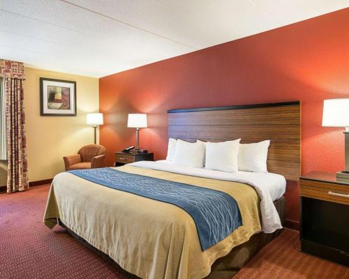 um quarto de hotel com uma cama grande e uma cadeira em Comfort Inn em Oxon Hill