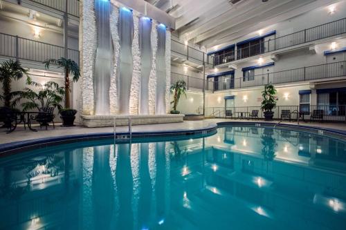 ein Pool in einem großen Gebäude mit eingeschalteten Lichtern in der Unterkunft Quality Inn Branson - Hwy 76 Central in Branson