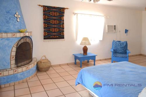1 dormitorio con chimenea, 1 cama y 1 silla en Casa Chapman by FMI Rentals, en Puerto Peñasco