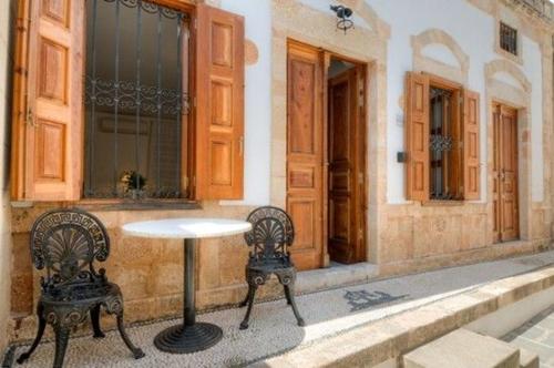 a table and two chairs in front of a building at Deluxe Rhodes Villa Villa Sokaki Well Furnished 2 Bedrooms Lindos in Lindos