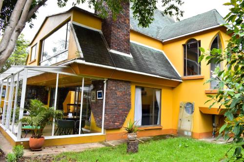a yellow house with a conservatory at Casa Iris in Chía