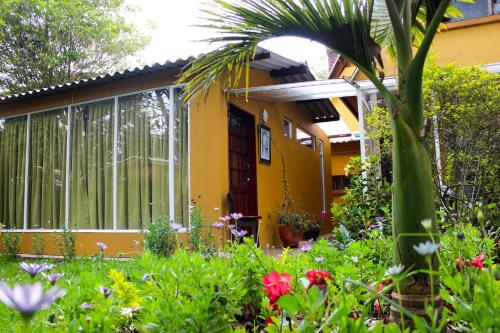 a yellow house with a garden in front of it at Casa Iris in Chía