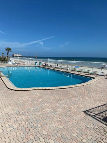 a swimming pool next to a beach with the ocean at Daytona Beach Inn Resort in Daytona Beach