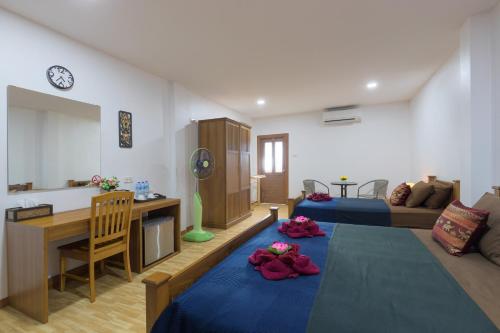 a living room with a bed and a table with flowers on it at Family Song Koh Lipe in Ko Lipe