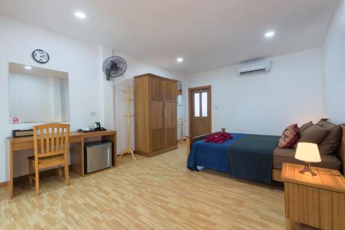 a bedroom with a bed and a desk and a chair at Family Song Koh Lipe in Ko Lipe