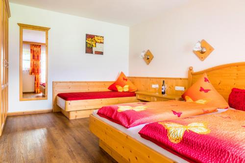 a bedroom with two beds and a mirror at Matzhof in Leogang