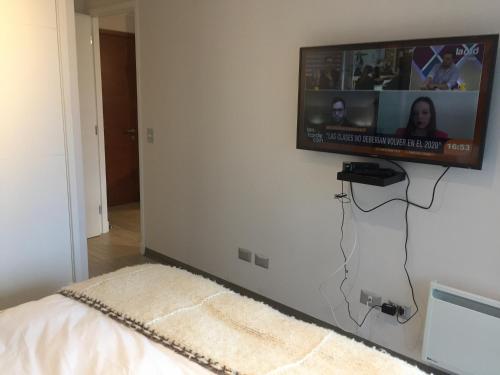 a flat screen tv hanging on a wall at Pucón Alta vista in Pucón