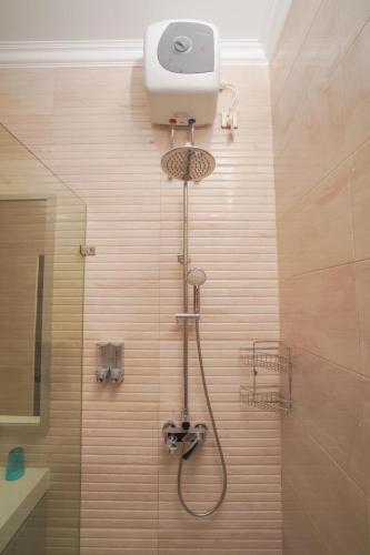 a shower with a shower head in a bathroom at Marseillia Hills in Puncak