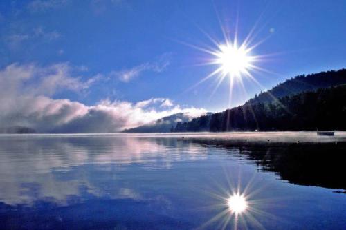a lake with the sun reflecting on the water at Brown's Beach at Schroon Lake in Schroon Lake