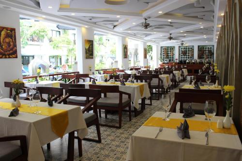 a restaurant with tables and chairs with yellow tablecloths at Khmer Mansion Residence in Siem Reap