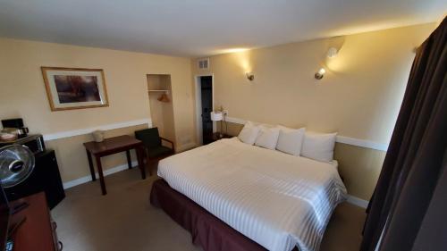 a hotel room with a bed and a bathroom at Comox Valley Inn & Suites in Courtenay