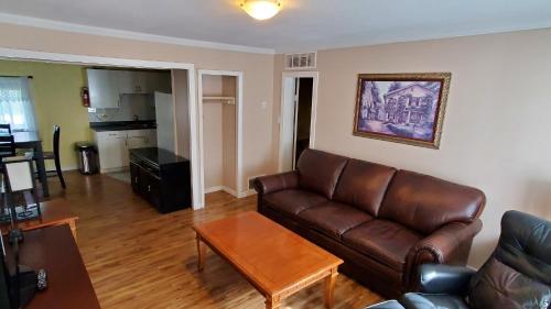 a living room with a leather couch and a table at Comox Valley Inn & Suites in Courtenay