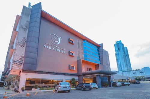 Un edificio con coches aparcados delante. en Saka Hotel Medan, en Sunggal