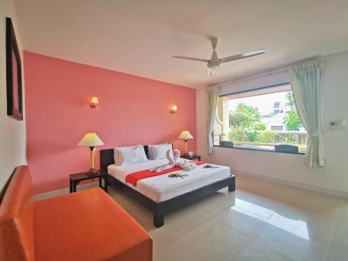 a bedroom with a bed with a red wall at Aumpai Luxury in Lamai