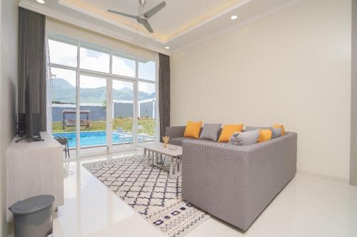 a living room with a couch and a tv at Marseillia Hills in Puncak