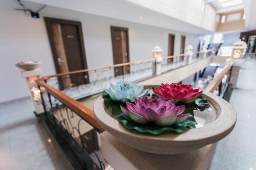 a planter with three flowers on a balcony at The Centris Hotel Phatthalung in Phatthalung