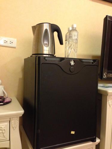 a black refrigerator with a water bottle on top of it at Doll House Lodge in Hengchun