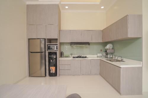 a kitchen with a stainless steel refrigerator and cabinets at Marseillia Hills in Puncak