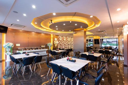 Un restaurante con mesas y sillas en una habitación. en The Centris Hotel Phatthalung, en Phatthalung