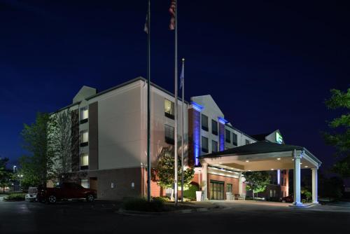 a building with a flag on top of it at night at Holiday Inn Express Hotel & Suites Milwaukee-New Berlin by IHG in New Berlin