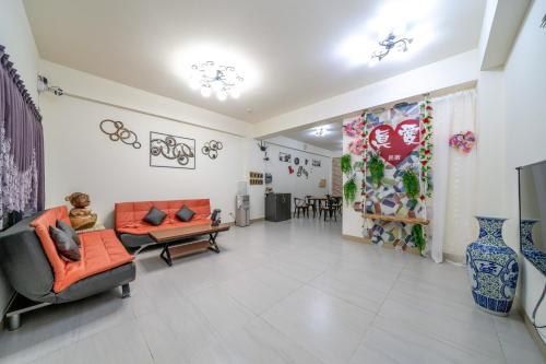 a living room with orange chairs and a couch at 真愛民宿-寵物友善-近東大門夜市-含車位 in Hualien City
