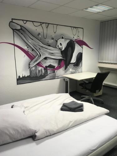 a bedroom with a panda painting on the wall at Hostel Hamm by Geronimo in Hamm