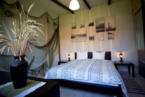 a bedroom with a bed and two tables with lamps at Guest House Baltās Dūjas in Saulkrasti