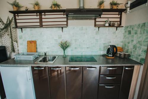 a kitchen with stainless steel cabinets and a sink at Guest House Baltās Dūjas in Saulkrasti
