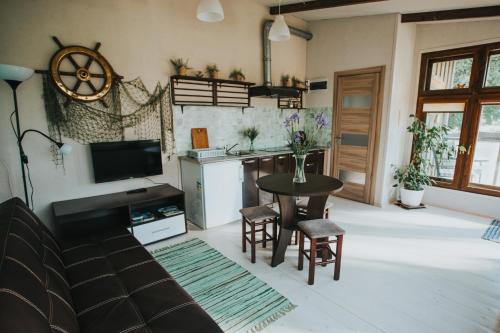 a living room with a table and a kitchen at Guest House Baltās Dūjas in Saulkrasti