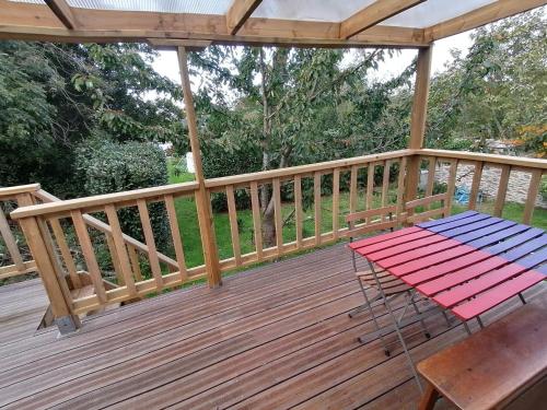 a wooden deck with a picnic table on it at Tipergwendiou in Plougonvelin